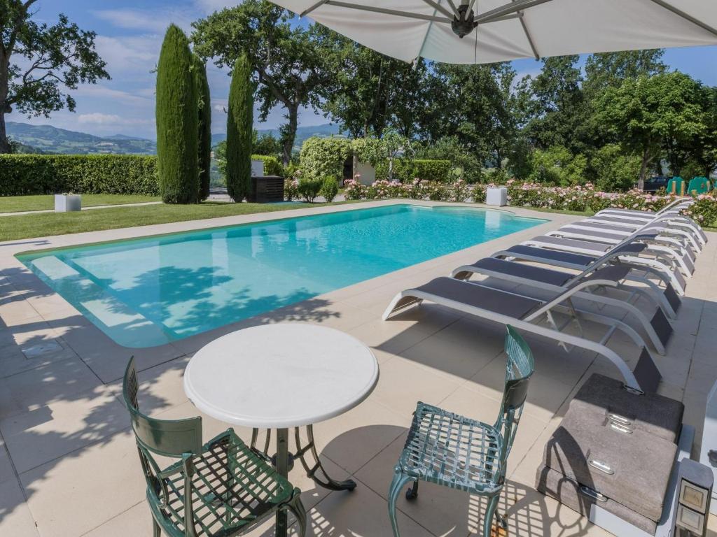 - une piscine avec des chaises, une table et un parasol dans l'établissement Scenic villa with heated pool, à SantʼIppolito
