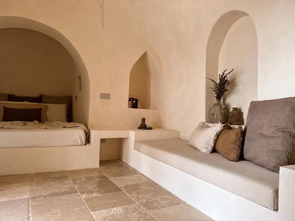 une chambre avec un lit et un canapé dans une pièce dans l'établissement Lumen Trullo, à Ostuni