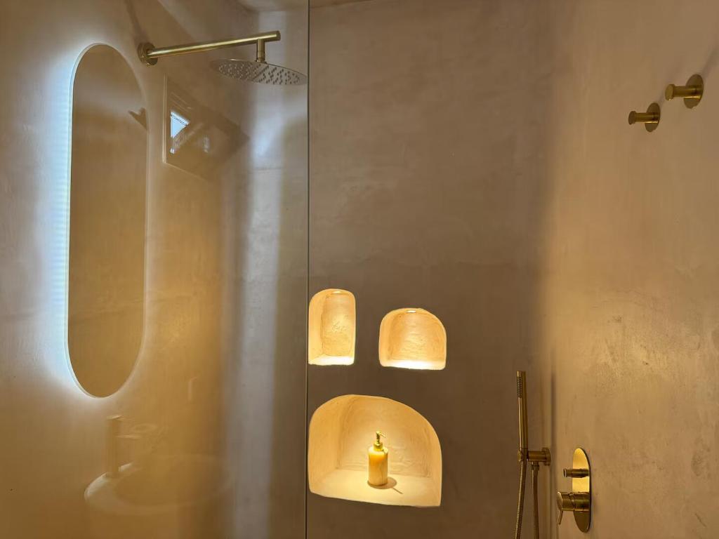une salle de bain avec une douche et une borne-fontaine jaune sur le mur dans l'établissement Lumen Trullo, à Ostuni 39 autres photos