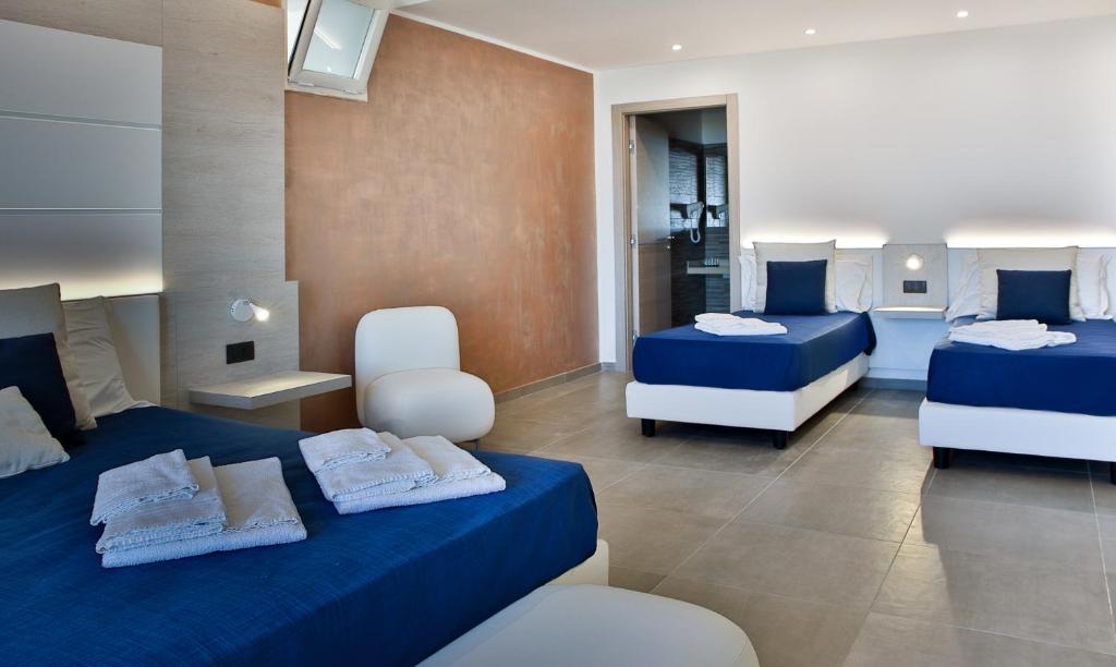 - une chambre avec deux lits et deux chaises dans l'établissement Hotel Sporting Club, à Altavilla Milicia