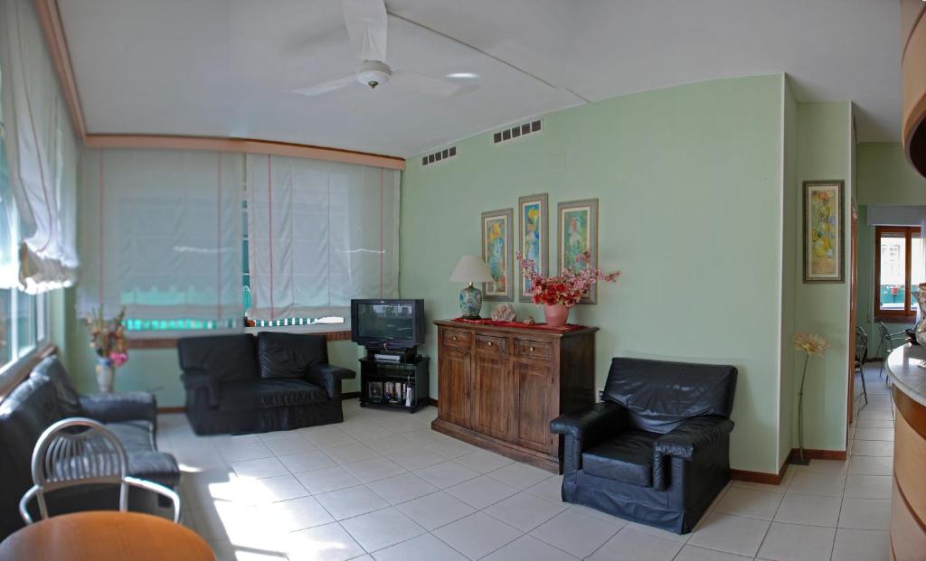 un salon avec deux fauteuils et une télévision dans l'établissement Hotel Michela, à Marina di Massa