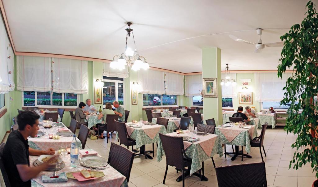 - une salle à manger avec des tables dans un restaurant dans l'établissement Hotel Michela, à Marina di Massa