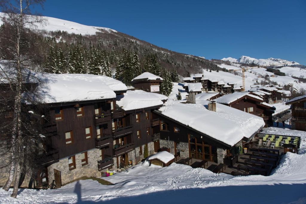 un groupe de bâtiments recouverts de neige sur une montagne dans l'établissement Villages Clubs du Soleil - VALMOREL, à Valmorel