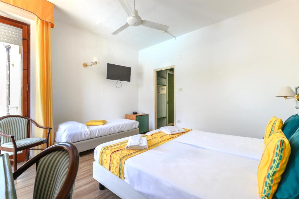 une chambre d'hôtel avec un lit et une télévision dans l'établissement Hotel in Capoliveri with private beach, à Capoliveri