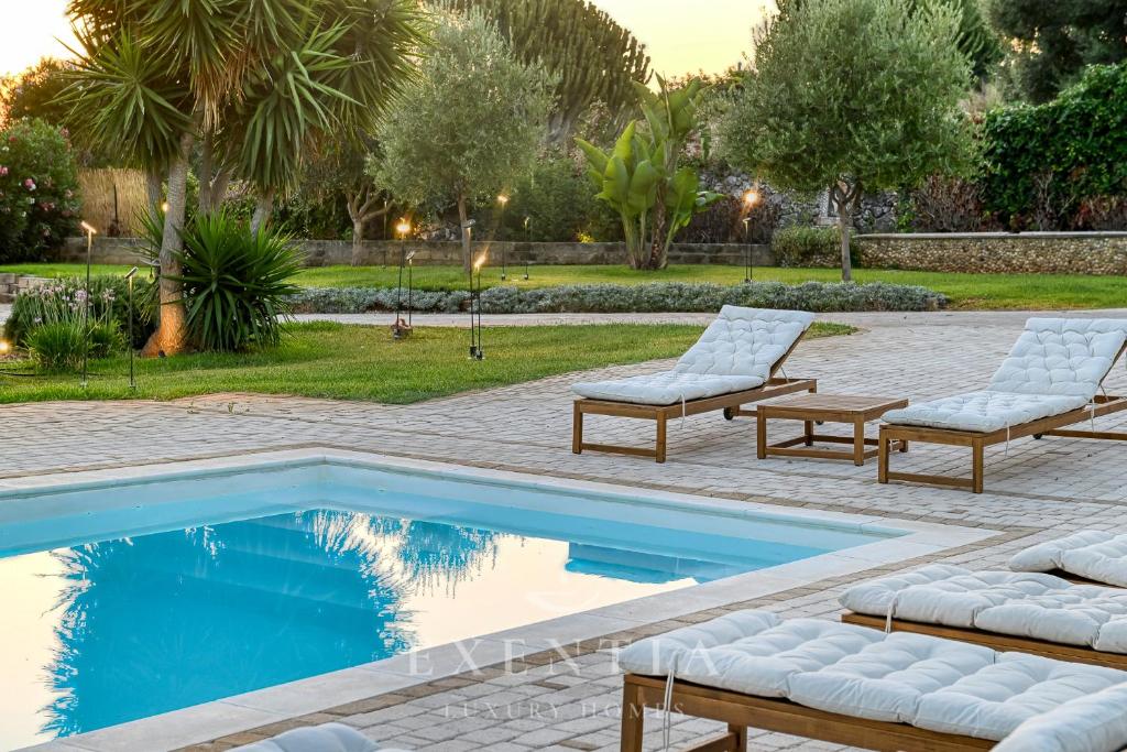 - une piscine avec 2 chaises longues à côté de la piscine dans l'établissement Luxury villa siracusa, à Syracuse 56 autres photos