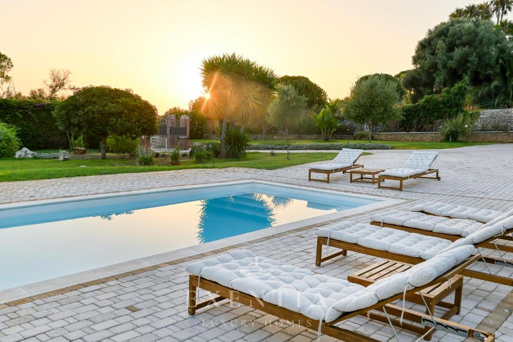 une piscine avec des chaises longues et une piscine dans l'établissement Luxury villa siracusa, à Syracuse