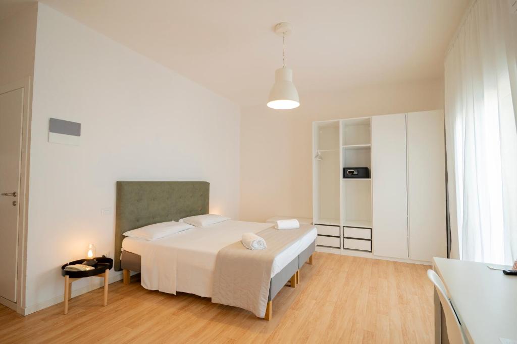 une chambre blanche avec un lit et une table dans l'établissement Hotel Concordia, à Lido di Jesolo