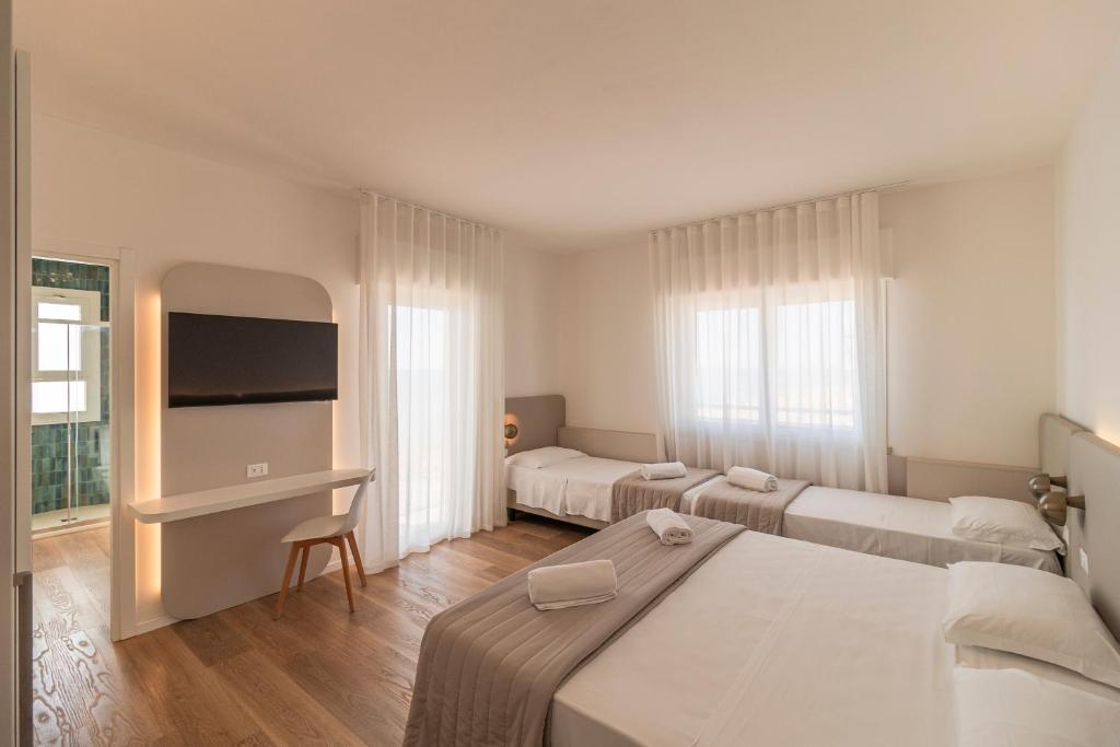 une chambre d'hôtel avec deux lits et une télévision à écran plat dans l'établissement Hotel Concordia, à Lido di Jesolo