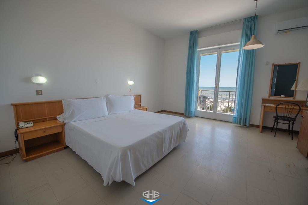 une chambre avec un lit, un bureau et une fenêtre dans l'établissement Grand Hotel Excelsior, à Senigallia 91 autres photos