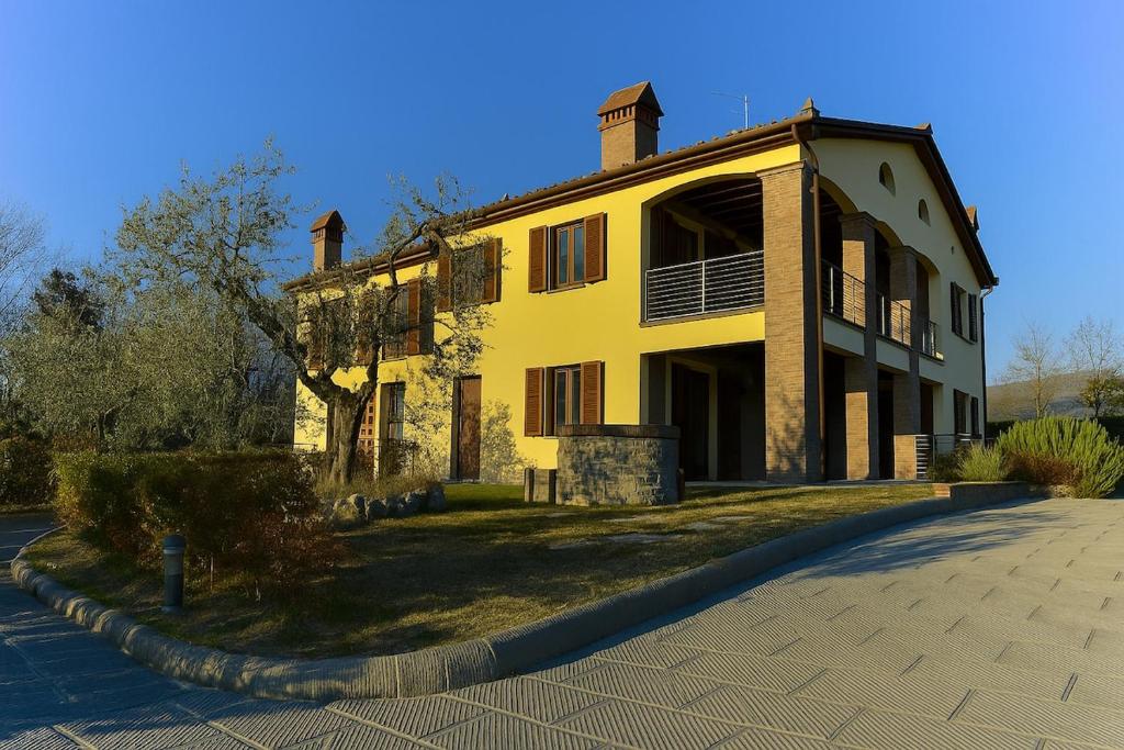 une grande maison jaune avec une allée en face de celle-ci dans l'établissement villa Diamante, à Lamporecchio