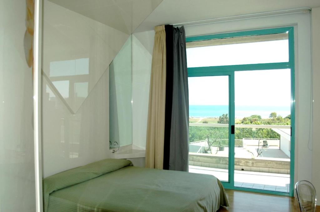 une chambre avec un lit et une grande fenêtre dans l'établissement Hotel Excelsior, à Vasto