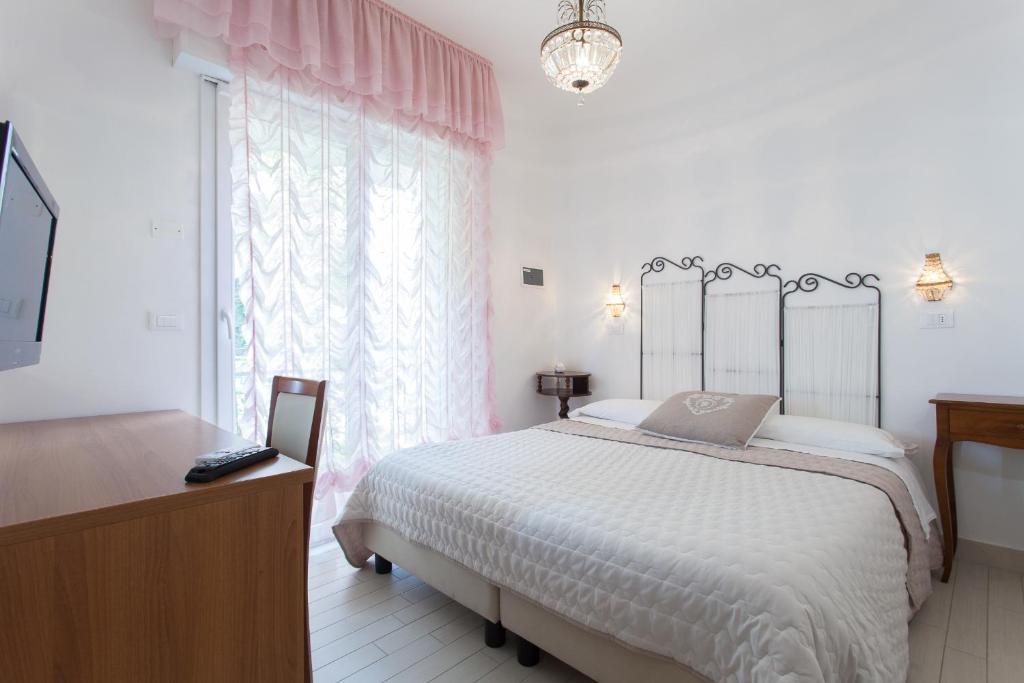 une chambre blanche avec un lit et une fenêtre dans l'établissement B&B Airone Cervia - Camere e Appartamenti, à Cervia