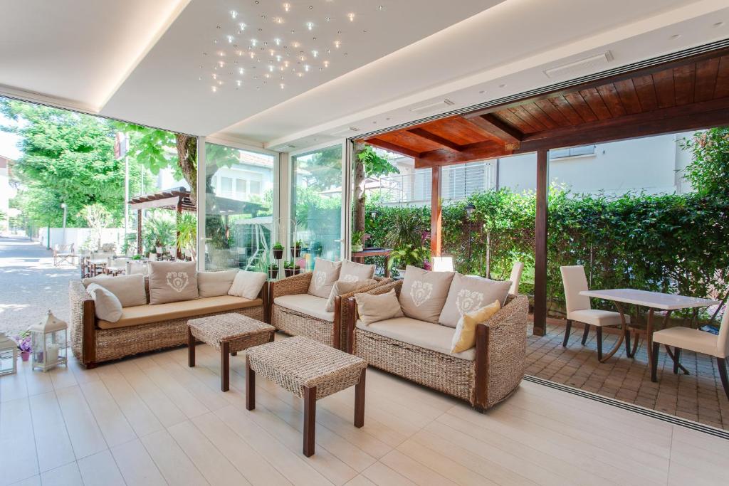 une terrasse avec des canapés, une table et des chaises dans l'établissement B&B Airone Cervia - Camere e Appartamenti, à Cervia