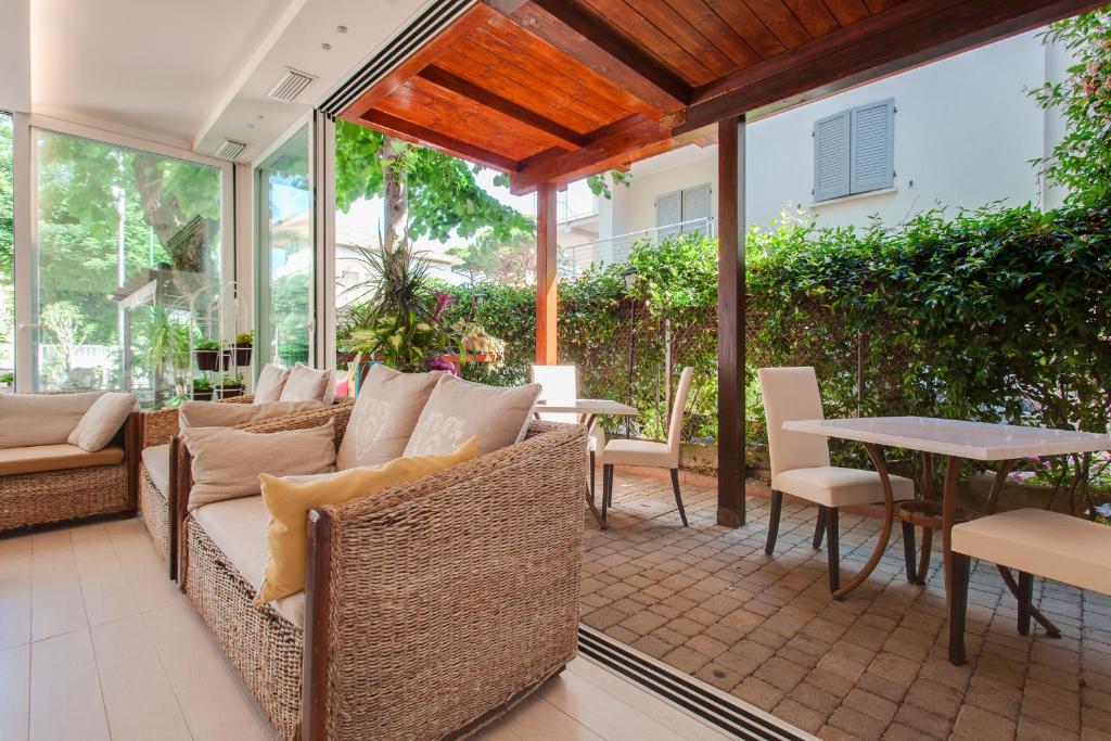 un patio extérieur avec des chaises en osier et une table dans l'établissement B&B Airone Cervia - Camere e Appartamenti, à Cervia 72 autres photos