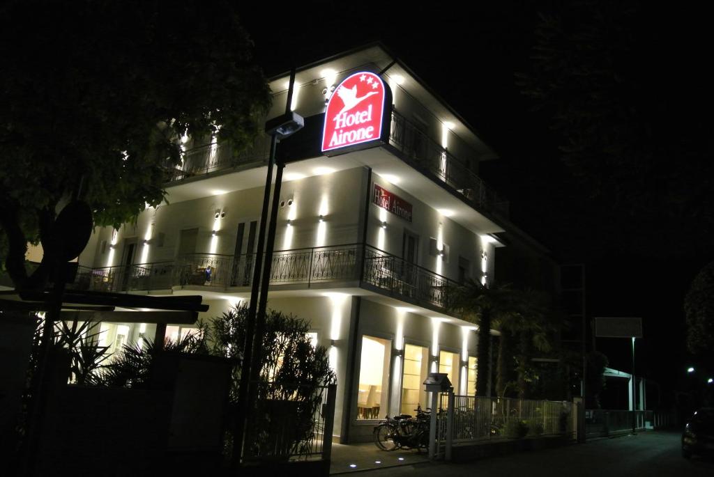 un bâtiment avec un panneau sur le côté la nuit dans l'établissement B&B Airone Cervia - Camere e Appartamenti, à Cervia