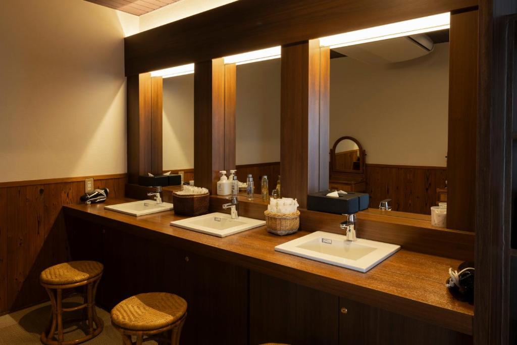 une salle de bain avec trois lavabos et deux miroirs dans l'établissement Ijika Daiichi Hotel Kagura, à Toba