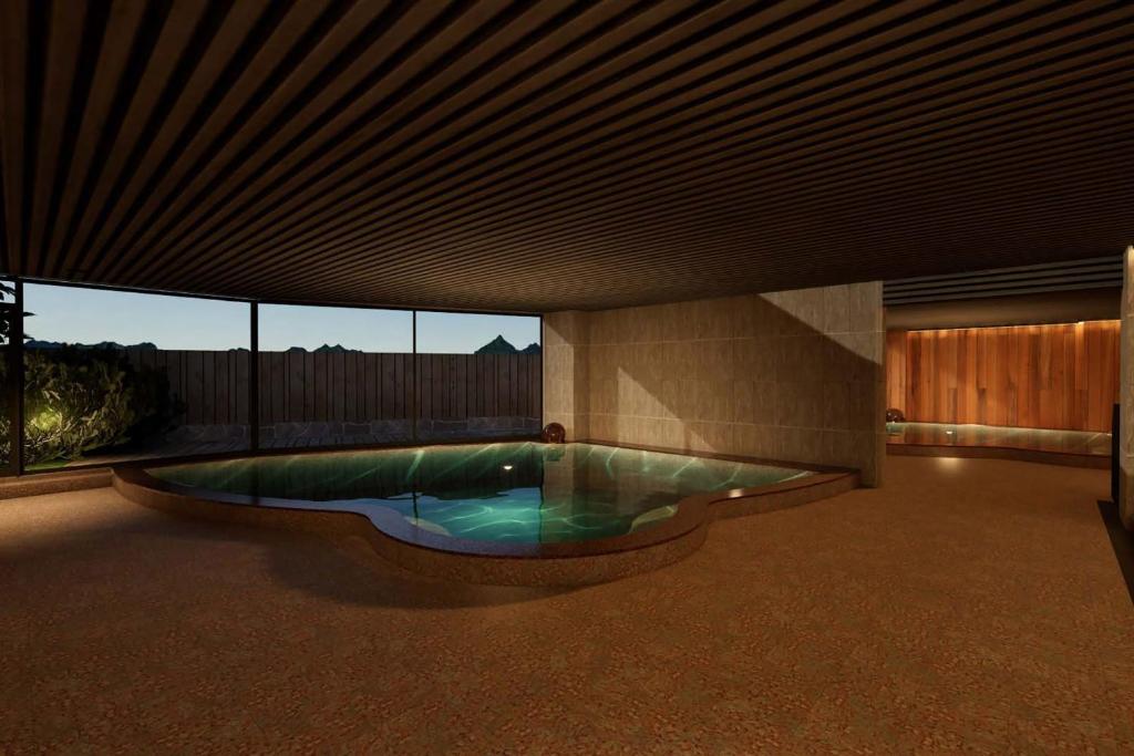 - une piscine au milieu d'une chambre avec un bâtiment dans l'établissement Ooedo Onsen Monogatari Premium Enakyo, à Ena