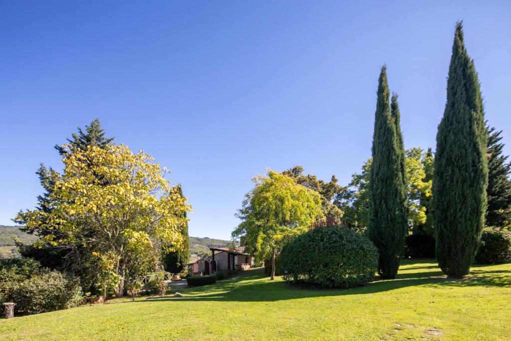 une cour avec des arbres et une maison en arrière-plan dans l'établissement Casa al Monte by VacaVilla, à Lamole 40 autres photos