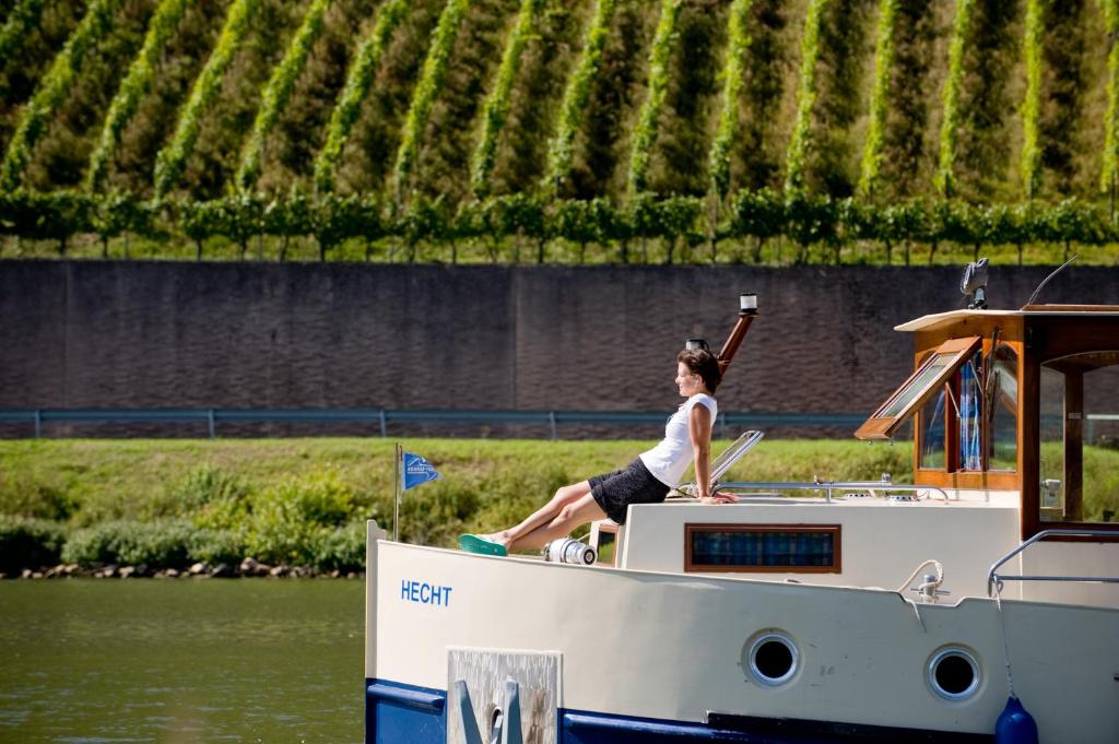 une femme assise sur un bateau dans l'eau dans l'établissement Kuhnle-Tours Niderviller, à Niderviller 6 autres photos