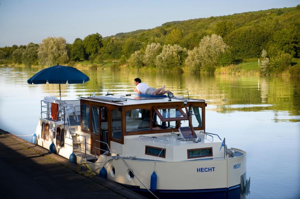 un homme assis sur un bateau dans l'eau dans l'établissement Kuhnle-Tours Niderviller, à Niderviller