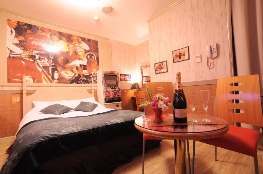 - une chambre avec un lit et une table avec une bouteille de vin dans l'établissement STAR RESORT Will, à Morioka