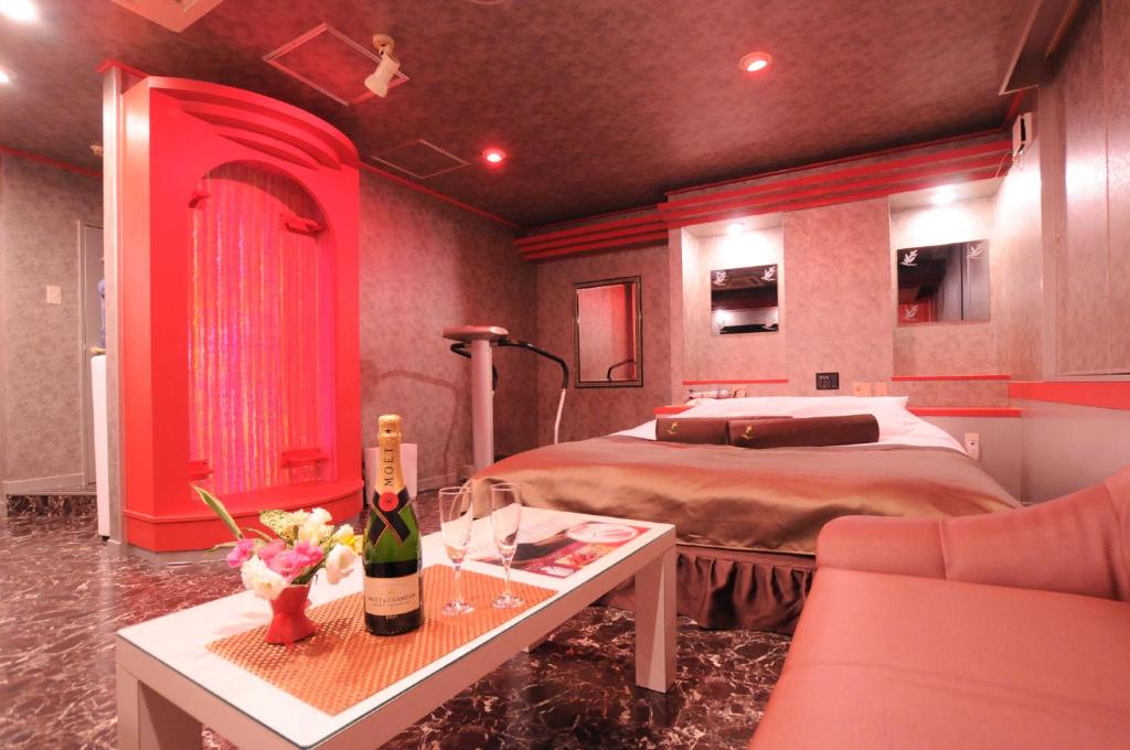 - une chambre avec un lit et une table avec une bouteille de vin dans l'établissement STAR RESORT Will, à Morioka