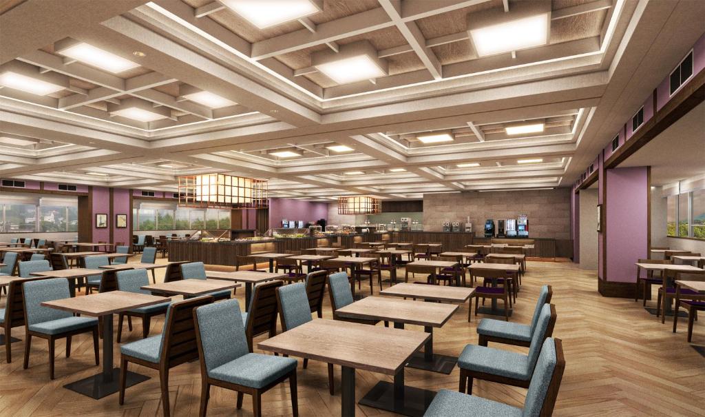 un restaurant avec des tables et des chaises dans une salle dans l'établissement KAMENOI HOTEL Kusatsu Resort, à Kusatsu