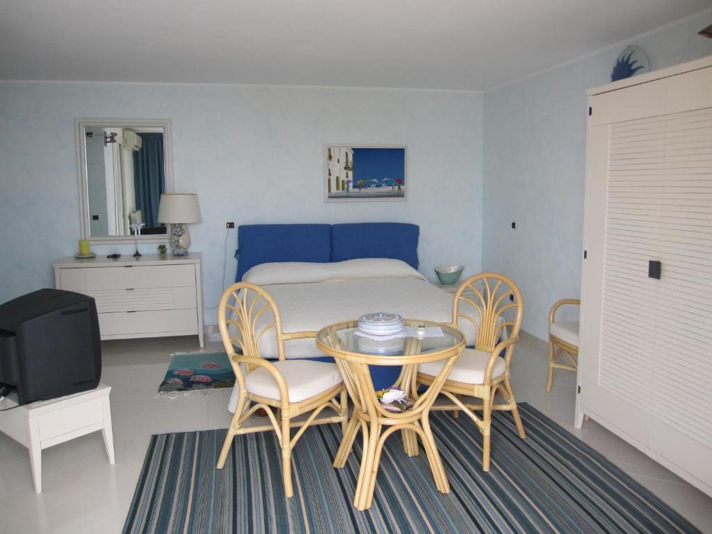 une chambre avec un lit, une table et des chaises dans l'établissement Villa Itati, à Sanremo