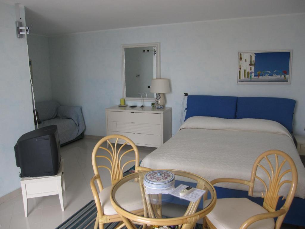 une chambre avec un lit, une table et des chaises dans l'établissement Villa Itati, à Sanremo 55 autres photos