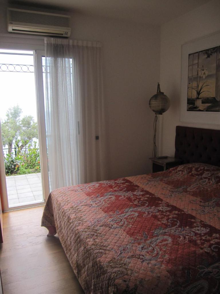 une chambre avec un lit et une porte coulissante en verre dans l'établissement Villa Itati, à Sanremo