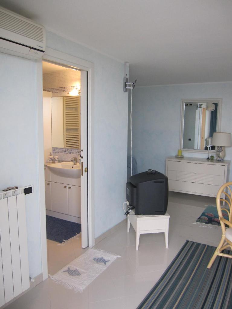 - une salle de bains blanche pourvue d'une télévision dans l'établissement Villa Itati, à Sanremo