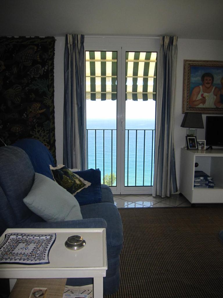 un salon avec un canapé et une fenêtre dans l'établissement Villa Itati, à Sanremo