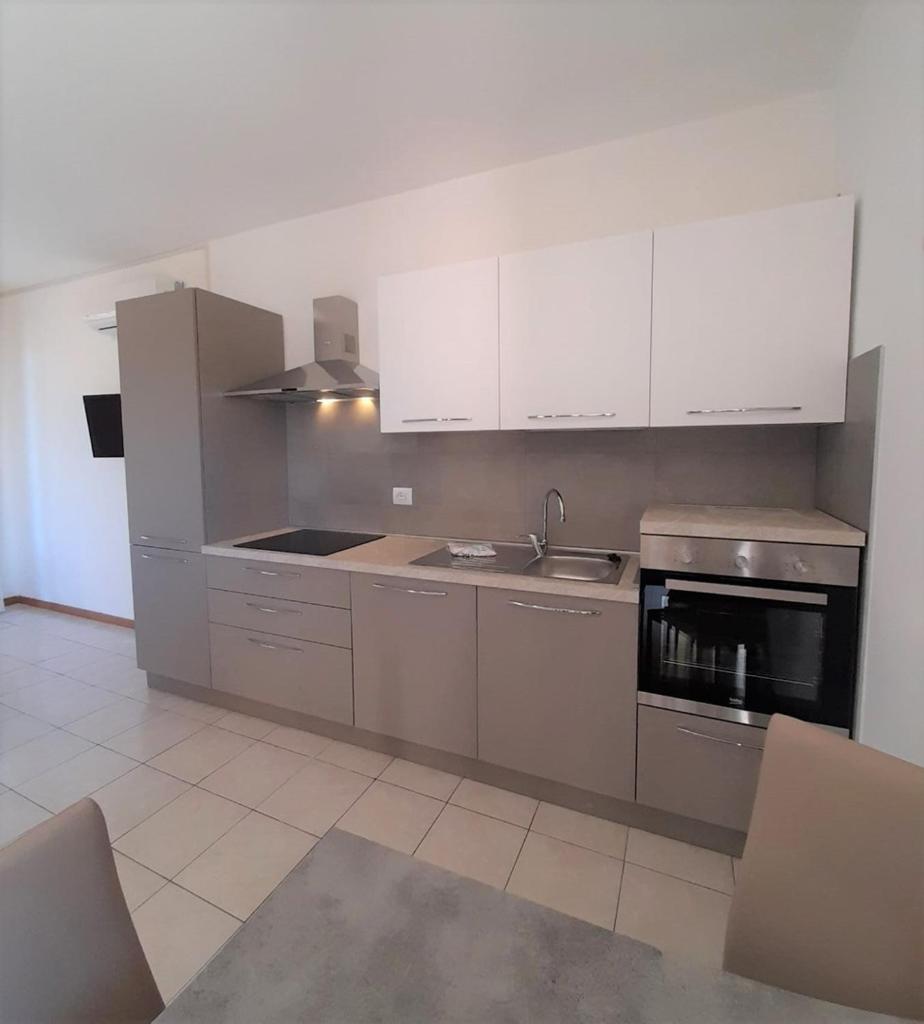 une cuisine avec des appareils en acier inoxydable et des armoires blanches dans l'établissement Aparthotel Costa Paradiso, à Lido Adriano