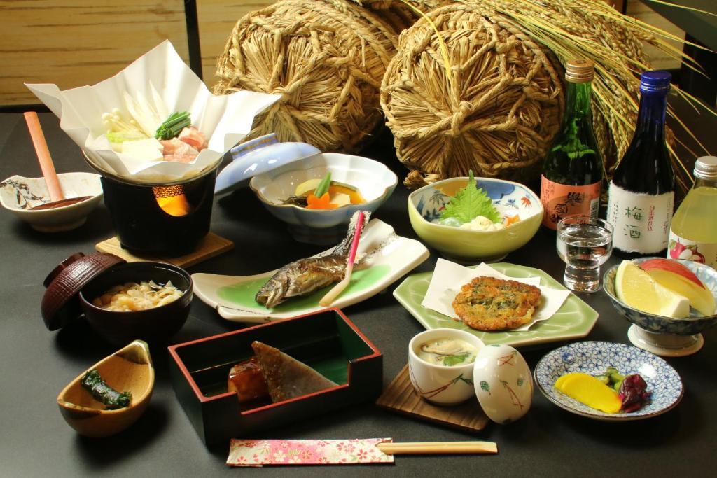 - une table avec des bols de nourriture et des bouteilles de vin dans l'établissement Nitaya, à Minakami 14 autres photos