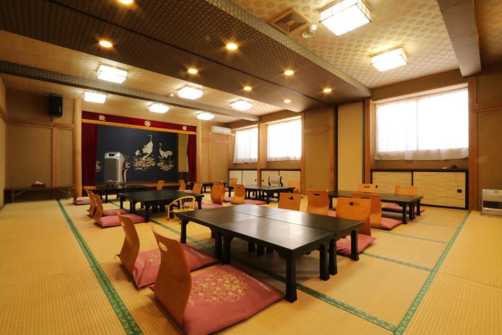 une salle de conférence avec des tables, des chaises et un écran dans l'établissement Nitaya, à Minakami
