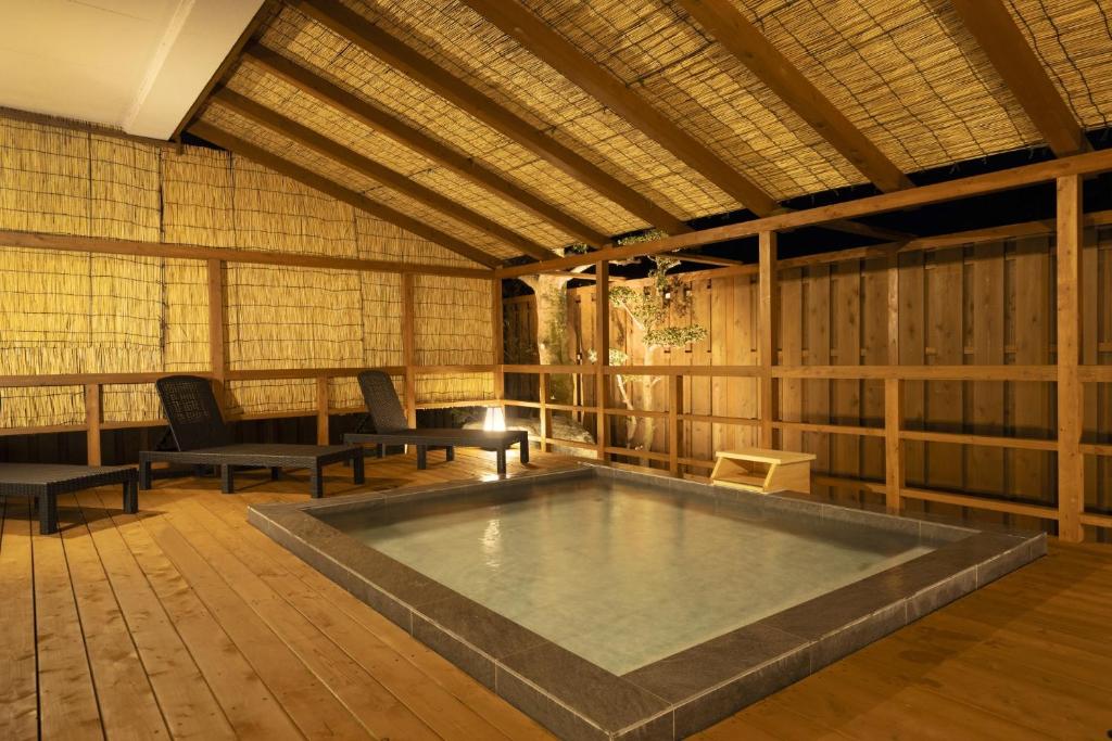 une grande piscine dans une pièce avec des chaises et une table dans l'établissement Ooedo Onsen Monogatari Premium Shima Saichoraku, à Shima 48 autres photos