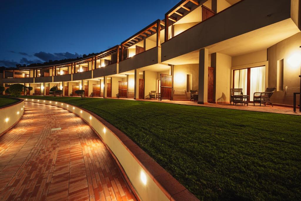 un grand bâtiment avec une pelouse devant dans l'établissement Is Molas Resort, à Pula