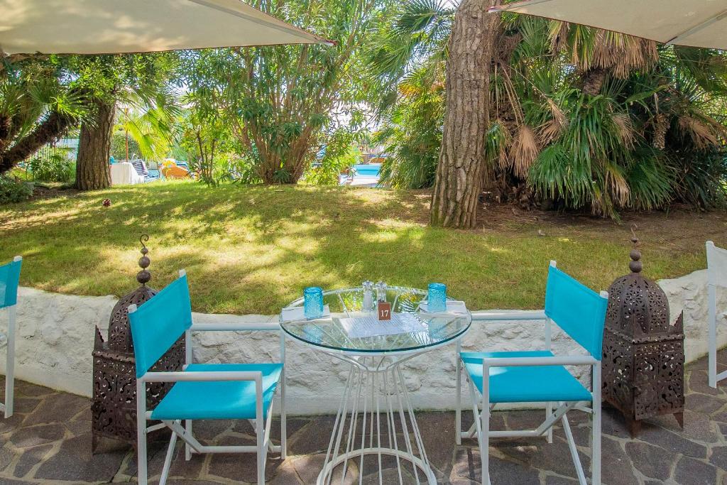 une table avec des chaises et un parasol sur une terrasse dans l'établissement Hotel Majestic, à Lido di Jesolo 71 autres photos