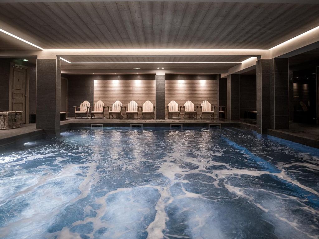 - une piscine avec des chaises dans le hall de l'hôtel dans l'établissement Le Fitz Roy, a Beaumier hotel, à Val Thorens