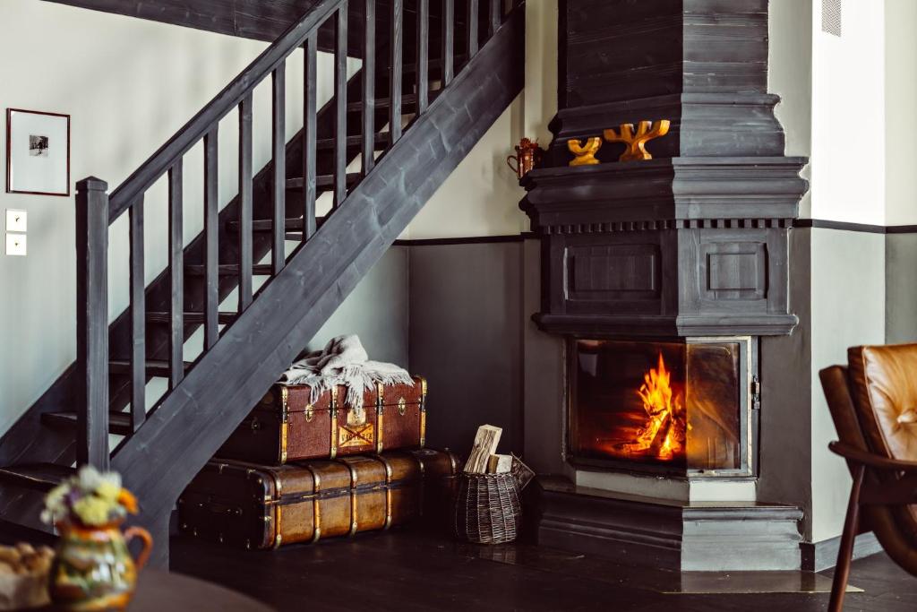 une cheminée dans un salon avec un escalier dans l'établissement Le Fitz Roy, a Beaumier hotel, à Val Thorens