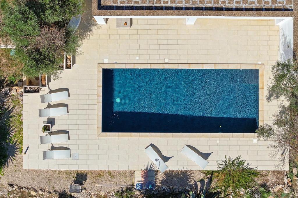 - une vue sur la piscine entourée de chaises dans l'établissement Casa Mathilde by Bianco Puglia Vacanze, à San Vito dei Normanni