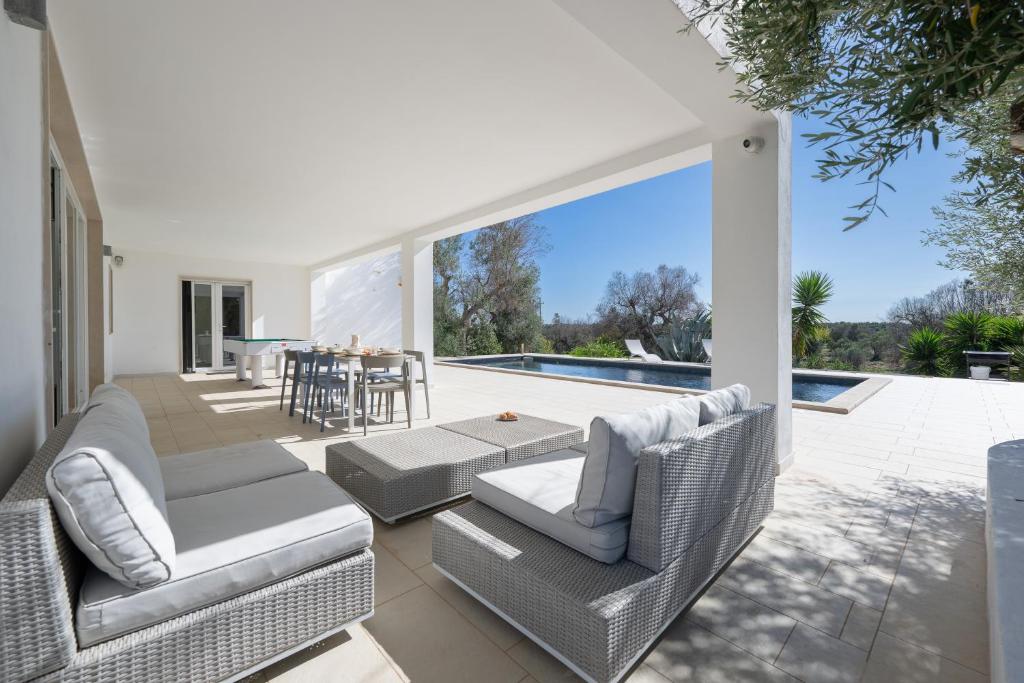 une terrasse avec des chaises, une table et une piscine dans l'établissement Casa Mathilde by Bianco Puglia Vacanze, à San Vito dei Normanni 34 autres photos