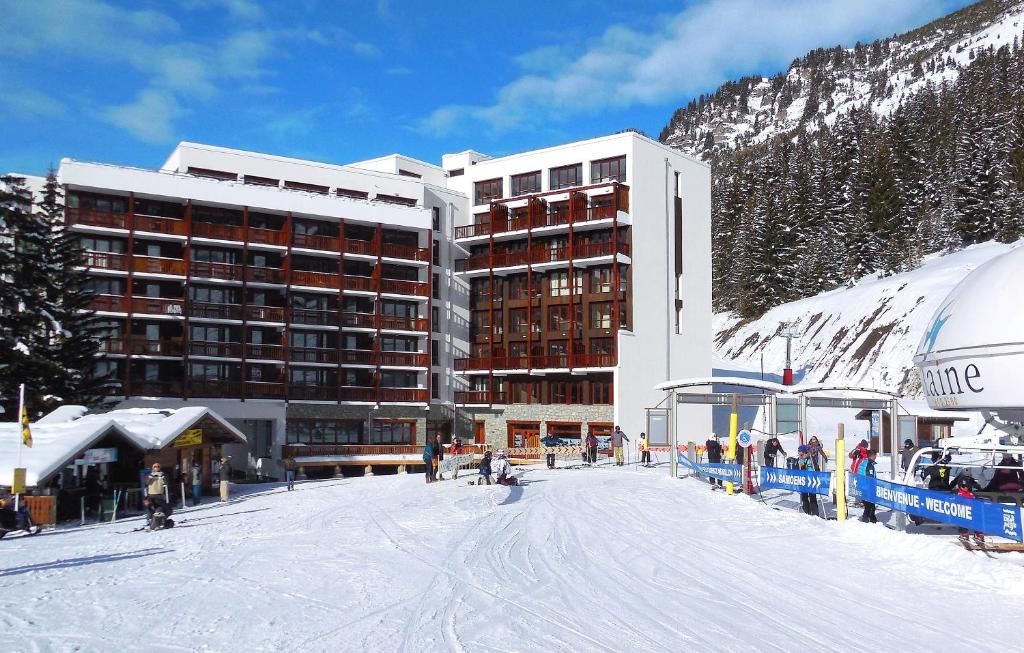 un grand bâtiment avec une piste de ski dans la neige dans l'établissement Résidence Odalys Le Panoramic, à Flaine