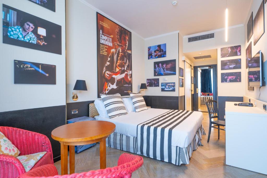 une chambre avec un lit, une table et des chaises dans l'établissement Admiral Art Hotel, à Rimini