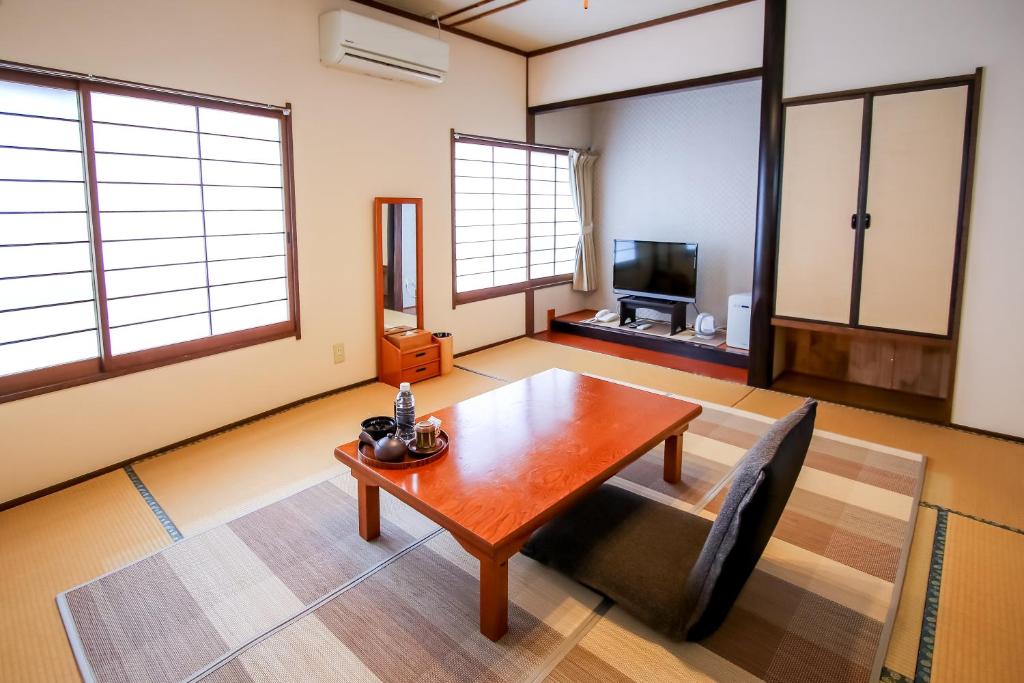 - un salon avec une table en bois et une télévision dans l'établissement 別府鉄輪温泉 萬力屋manrikiya, à Beppu 36 autres photos