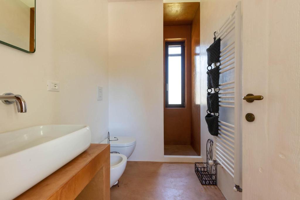 une salle de bain avec une baignoire blanche et des toilettes dans l'établissement Villa Malusida by Perle di Puglia, à Carovigno