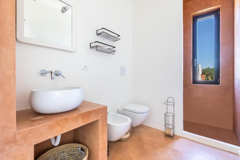 une salle de bain avec un lavabo et des toilettes dans l'établissement Villa Malusida by Perle di Puglia, à Carovigno 35 autres photos