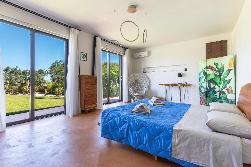 une chambre avec un lit et une grande fenêtre dans l'établissement Villa Malusida by Perle di Puglia, à Carovigno