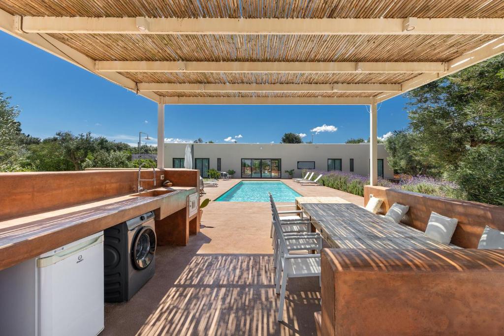un patio extérieur avec une table et des chaises ainsi qu'une piscine dans l'établissement Villa Malusida by Perle di Puglia, à Carovigno