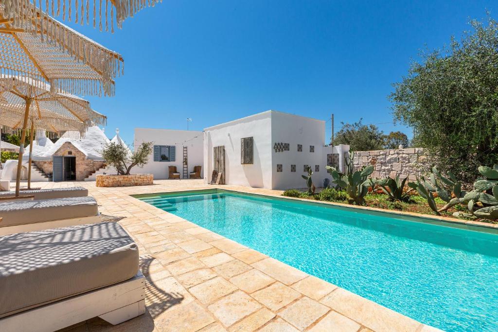 une piscine devant une villa dans l'établissement O` Trullo Mio by Perle di Puglia, à Ostuni